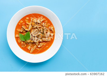 Panaeng Curry with pork in white bowl on blue Panaeng Curry with pork in white bowl on blue 63907162