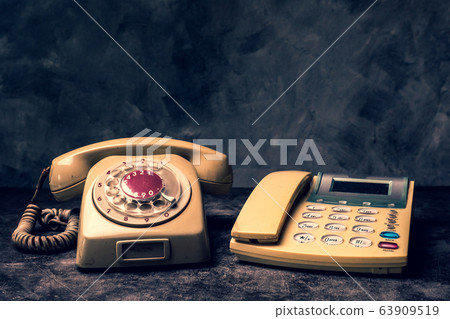 An old telephone with rotary dial and a landline on a grunge background. 63909519