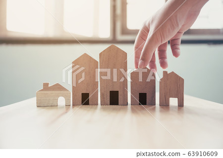 Hand choosing wooden house model 63910609