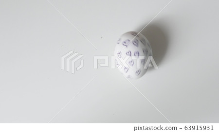 Egg spinning.Chicken egg spinning on white background top view. Egg spinning and rolling on the white background Happy Easter.Easter painted egg spinning on a white background. Egg spinning.Chicken egg spinning on white background top view. Egg spinning and rolling on the white background Happy Easter.Easter painted egg spinning on a white background. 63915931