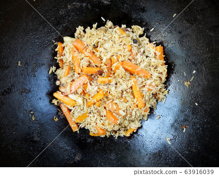 Cast iron bowl pilaf, wide black plate is filled 63916039