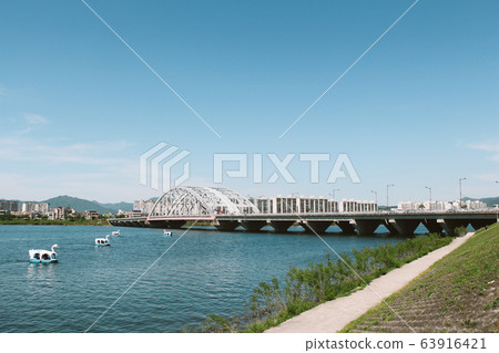 Duck boat and bridge and apartment on riverside park in Chuncheon, Korea 63916421