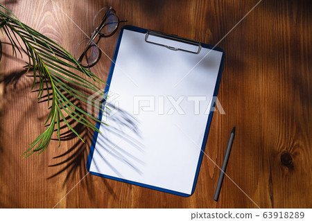 Creative and cozy workplace at home office, inspirational mock up with plant shadows on table surface Creative and cozy workplace at home office, inspirational mock up with plant shadows on table surface 63918289