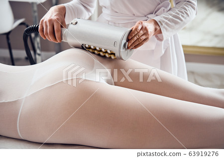Masseur makes apparatus anti-cellulite massage in the cosmetology clinic 63919276