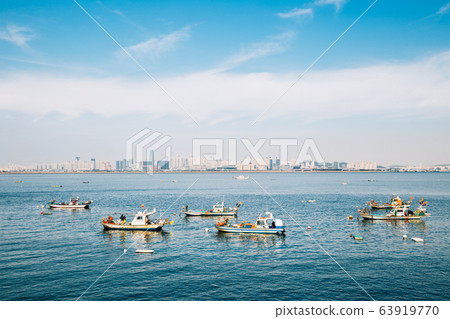 Incheon cityscape and sea with fishing boats from Sihwa tide embankment in Korea Incheon cityscape and sea with fishing boats from Sihwa tide embankment in Korea 63919770