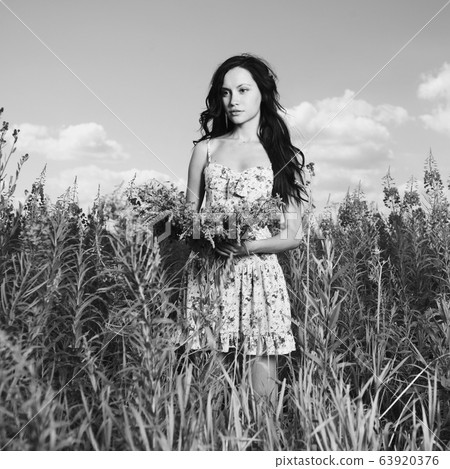 Lady in a flower meadow 63920376