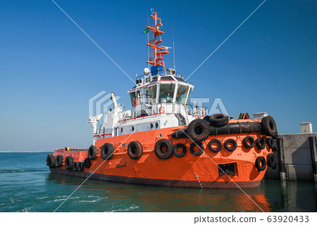 Tug boat with bright orange hull Tug boat with bright orange hull 63920433
