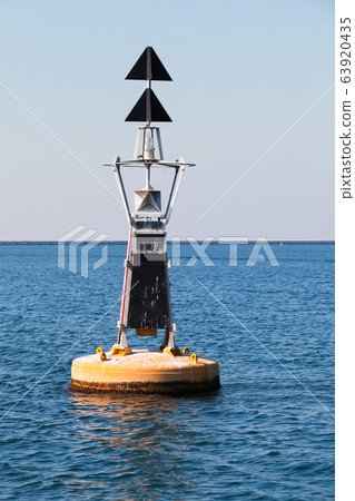 Yellow black North Cardinal buoy is on water 63920435