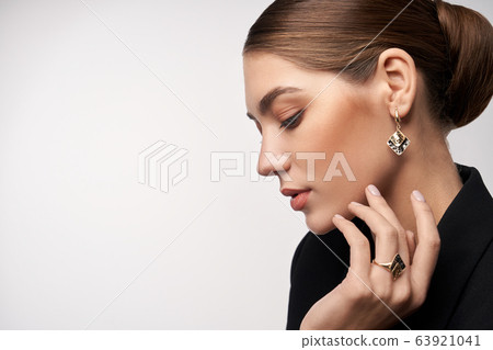 Model demonstrating earrings and ring. 63921041