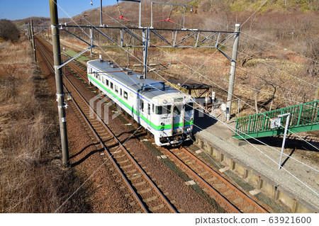 Photographing the scenery of an ordinary train arriving and departing from JR Tokanehama Station in Shiraoi-cho, Hokkaido in early spring Photographing the scenery of an ordinary train arriving and departing from JR Tokanehama Station in Shiraoi-cho, Hokkaido in early spring 63921600