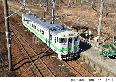 拍攝早春從北海道白老町JR Tokanehama站進出的普通火車的景色 63921601
