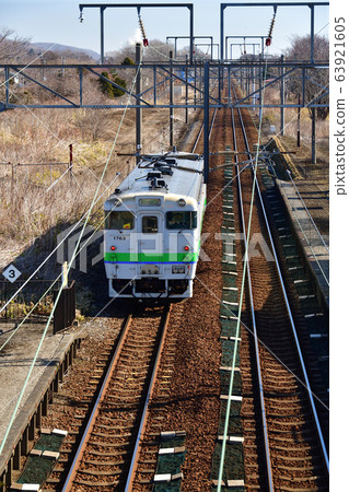拍攝早春從北海道白老町JR Tokanehama站進出的普通火車的景色 63921605