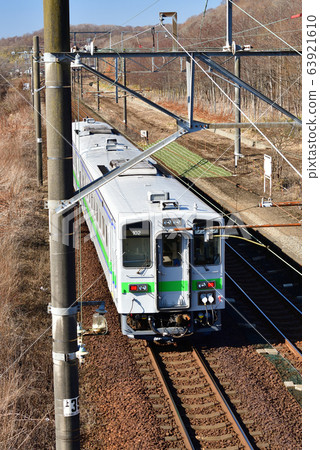 拍攝早春從北海道白老町JR Tokanehama站進出的普通火車的景色 63921610
