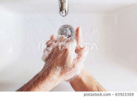 Man cleaning his hands using liquid disinfectant soap. Man cleaning his hands using liquid disinfectant soap. 63923389