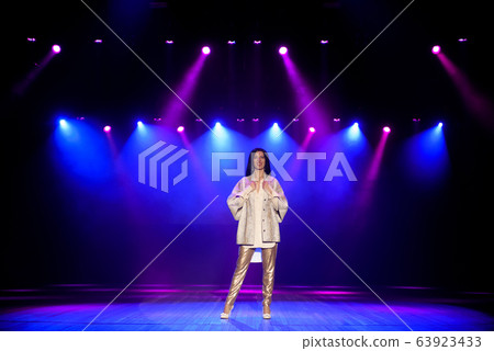 Actress on the stage in colorful bright beams of light. 63923433