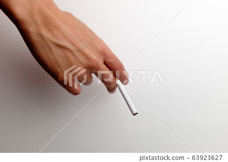 Hand holding a cigarette Hand holding a cigarette 63923627