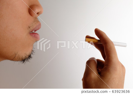 Hand holding a cigarette Hand holding a cigarette 63923636
