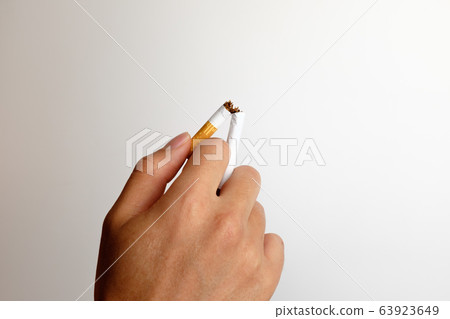 Hand holding a cigarette Hand holding a cigarette 63923649