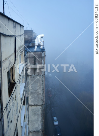 Worker scientist wearing protective coverall and gas mask doing ecological tests on the roof Worker scientist wearing protective coverall and gas mask doing ecological tests on the roof 63924138