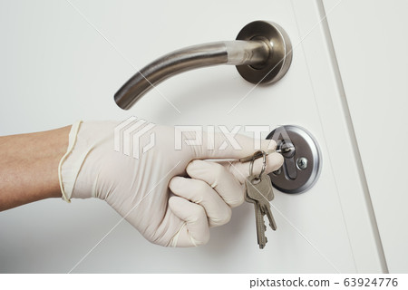 man opening a door wearing latex gloves man opening a door wearing latex gloves 63924776