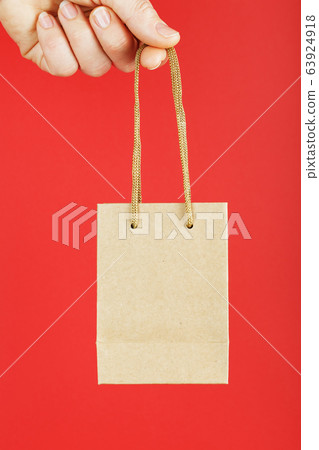 A small paper bag at arm's length isolated on a A small paper bag at arm's length isolated on a 63924918