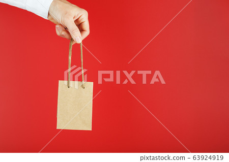 A small paper bag at arm's length isolated on a A small paper bag at arm's length isolated on a 63924919