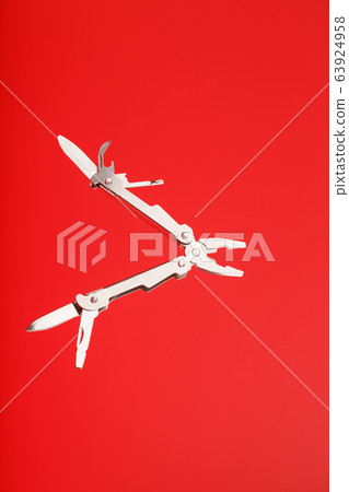 Multitool is a multi-functional tool on a red Multitool is a multi-functional tool on a red 63924958
