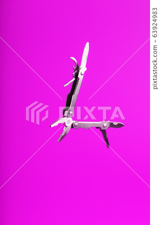 Multitool is a multi-functional tool on a pink Multitool is a multi-functional tool on a pink 63924983