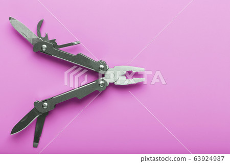 Multitool is a multi-functional tool on a pink Multitool is a multi-functional tool on a pink 63924987