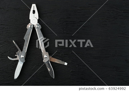 Multitool is a multi-functional tool on a black Multitool is a multi-functional tool on a black 63924992