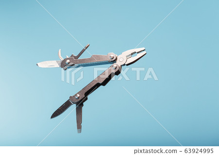 The multitool multi-function tool hovers on a blue The multitool multi-function tool hovers on a blue 63924995