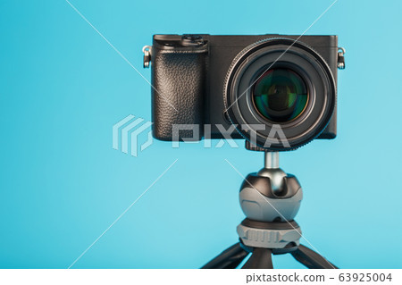 Professional camera on a tripod, on a blue Professional camera on a tripod, on a blue 63925004
