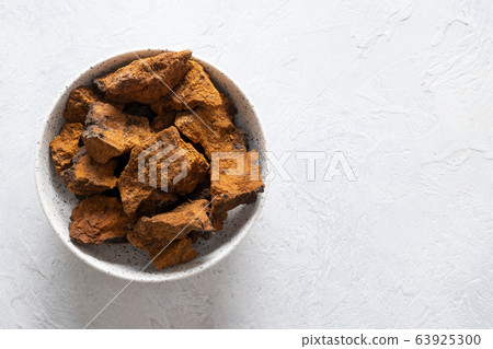 Chaga Birch Mushrooms in bowl on light table. Chaga Birch Mushrooms in bowl on light table. 63925300
