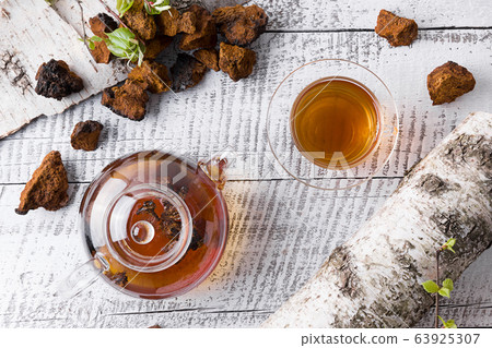 Chaga mushrooms infusion in glass teapot on white 63925307