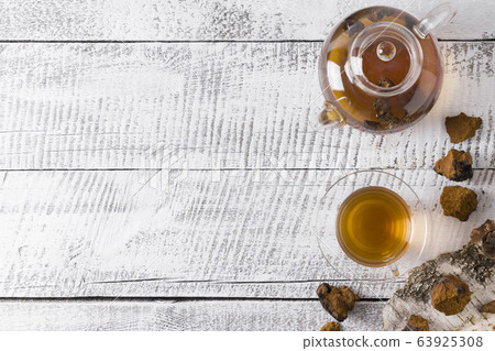 Chaga mushrooms infusion in glass teapot on white Chaga mushrooms infusion in glass teapot on white 63925308