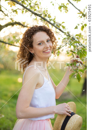 Young attractive woman with curly hair walking in 63925491
