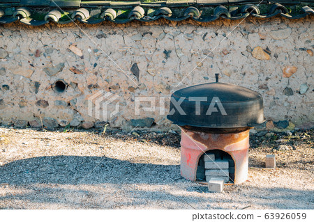 Iron pot and Korean traditional fireplace at Gyochon Hanok Village in Gyeongju, Korea Iron pot and Korean traditional fireplace at Gyochon Hanok Village in Gyeongju, Korea 63926059