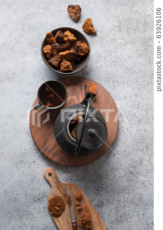 Chaga infusion beverage in cup on grey Chaga infusion beverage in cup on grey 63926106
