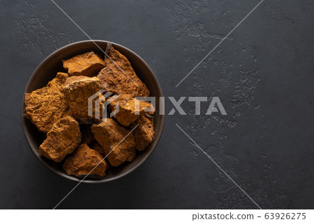 Chaga Birch Mushrooms in bowl on black table. Chaga Birch Mushrooms in bowl on black table. 63926275
