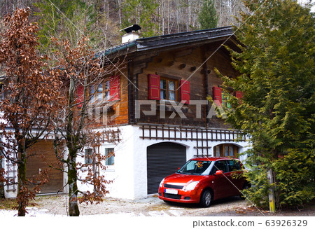Typical building in Bavaria, Germany. Modern wooden house and car Typical building in Bavaria, Germany. Modern wooden house and car 63926329