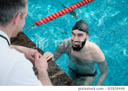 Smiling swimmer listening to coach 63926446