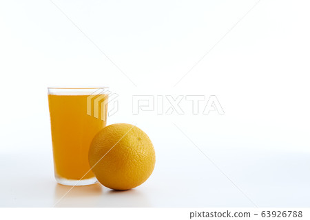 glass of orange juice and orange pieces 63926788