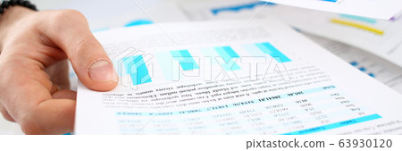 Male arm holding papers with business statistics Male arm holding papers with business statistics 63930120