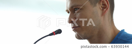 Man speaks in front microphone, informal meeting 63930144