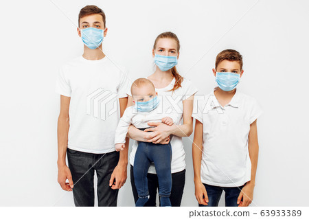 Family parents and children wear medical masks to 63933389
