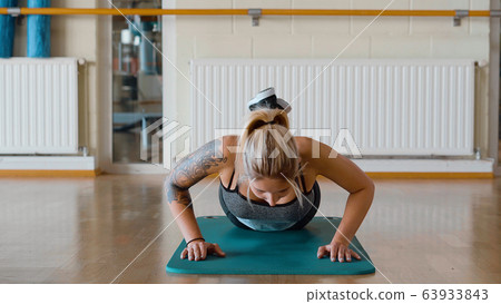 Young girl doing push ups at a gym Young girl doing push ups at a gym 63933843