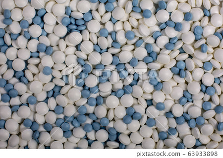 whote and blue pills lie on table background. Drugs, painkillers, colds 63933898