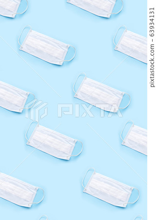Disposable medical mask on blue background. 63934131