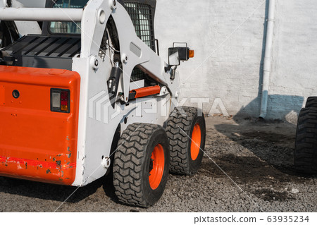 White skid steer loader at a construction site waiting of work. Industrial machinery. Industry. 63935234