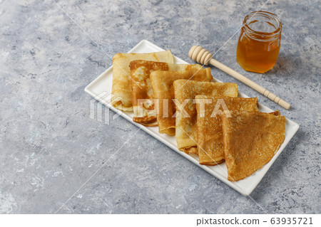 Delicious Breakfast on light background. Orthodox holiday Maslenitsa. Crepes with cumquats and honet,top view 63935721